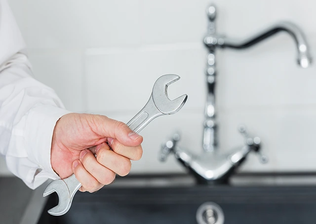 Plombier réparant un WC dans une salle de bain avec outils professionnels